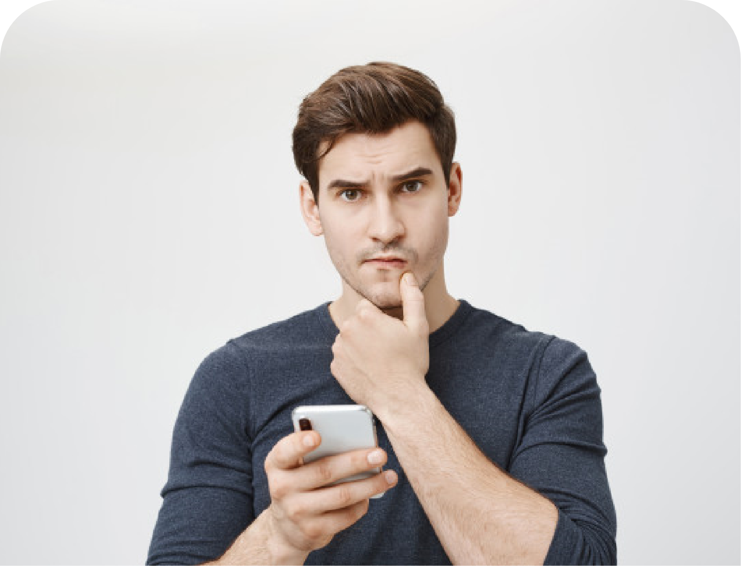 man with hand on his chin thinking while using a smart phone